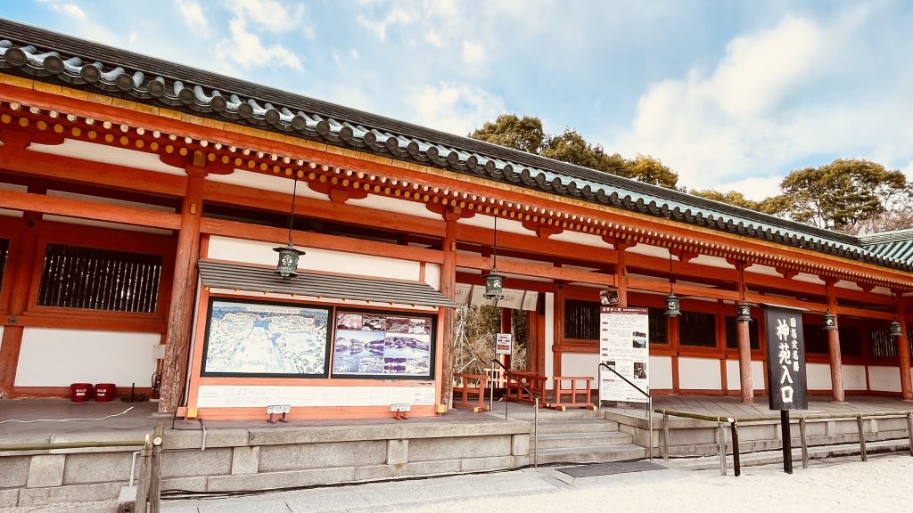 京都・平安神宮の境内にある神苑入口の案内板と朱色の社殿