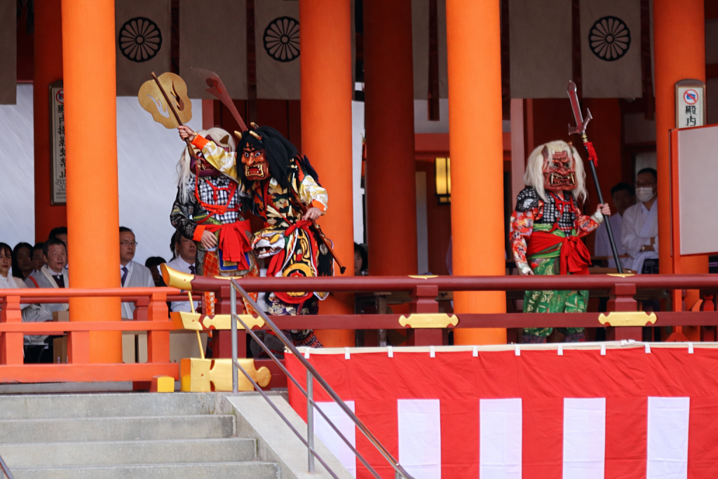 平安神宮の本殿前の舞台に現れた節分の鬼たち。色鮮やかな装束をまとい、豆を受けながら力強く動き回る様子