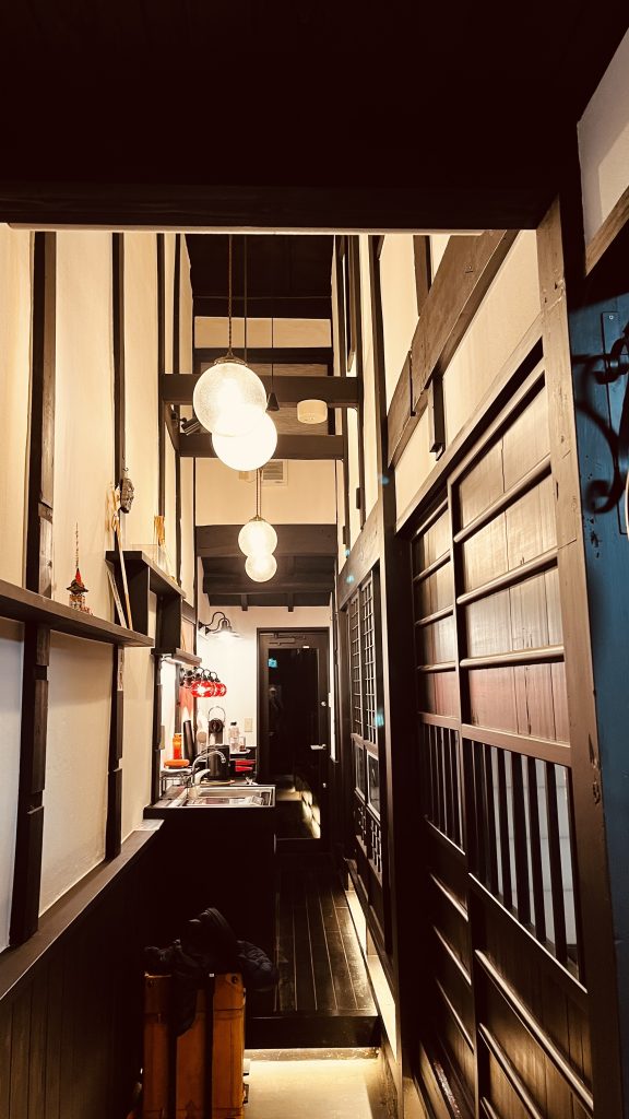 温かい灯りに照らされた、京町家の廊下と台所