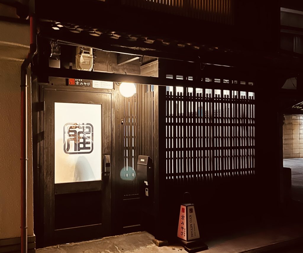 京都の街中、小さな交差点の角にある京町家宿の外観