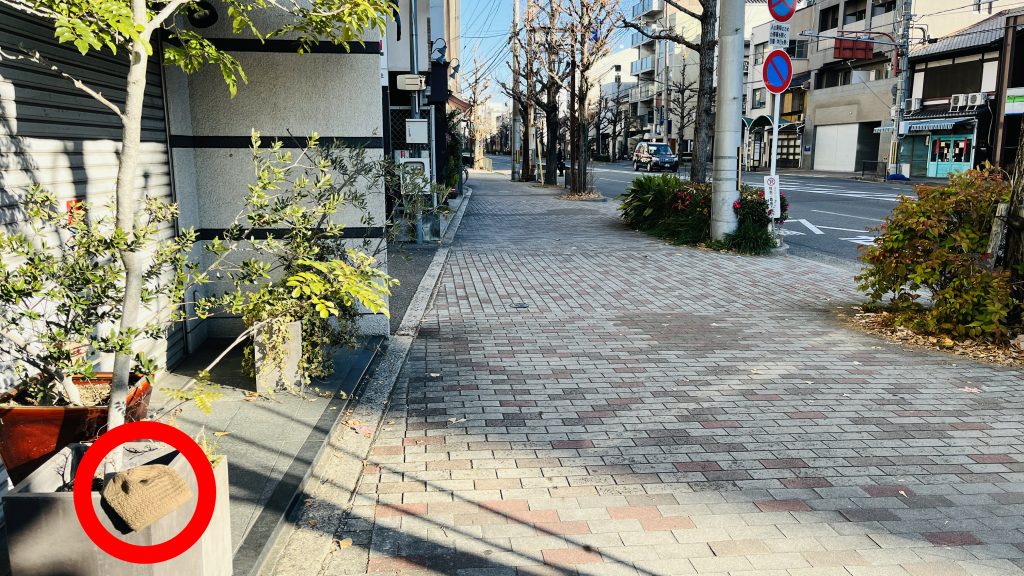 京都の歩道の植木鉢の上に、落とされた子どもの帽子がそっと置かれている