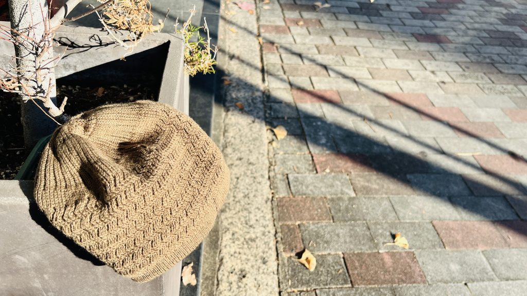 植木鉢の縁に置かれた、落とし物の子どものニット帽
