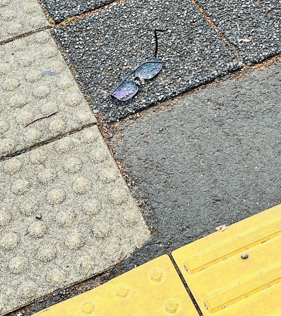 歩道の端に落ちている黒い眼鏡