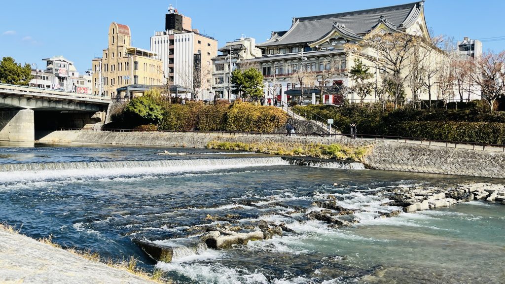 四条大橋のたもと、段差を流れる水音が響く鴨川の風景