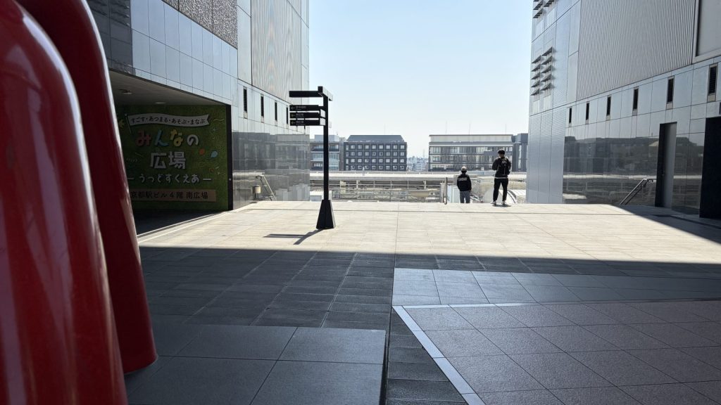 京都駅。赤いモニュメントの横を通り過ぎる