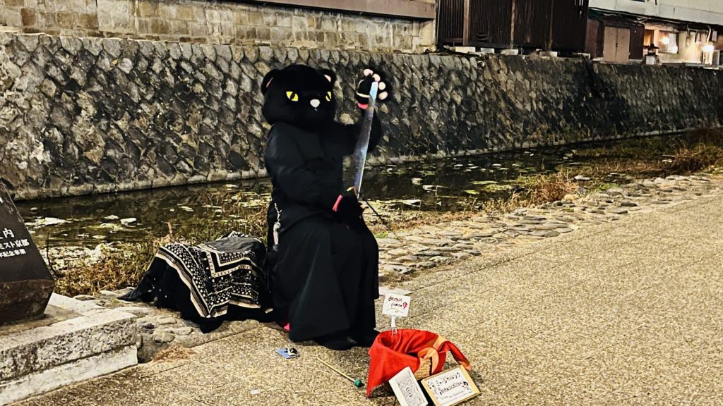 ねこのかぶりもので二胡を弾く人